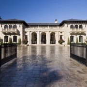 A formal symmetry reinforces the grandeur of this building, courtyard, estate, facade, hacienda, home, house, mansion, property, real estate, sky, villa