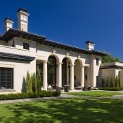 All the large arched openings in this Mediterranean-style building, estate, facade, grass, historic house, home, house, lawn, mansion, official residence, property, real estate, residential area, sky, stately home, villa, window, blue