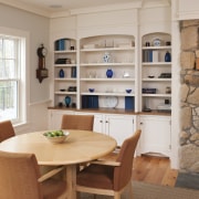 In this remodeled cottage, the cabinetry in dining bookcase, cabinetry, furniture, interior design, living room, shelf, shelving, table, gray, brown