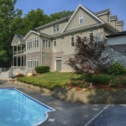 DCG's work did not stop with the interior. backyard, cottage, estate, home, house, landscape, landscaping, mansion, outdoor structure, plant, property, real estate, residential area, siding, swimming pool, villa, water, yard