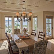 In this Cape Cod home, the adjacent dining dining room, door, estate, home, interior design, living room, real estate, room, window, brown