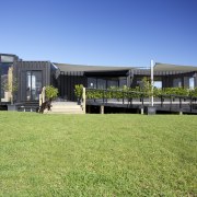 Four containers were linked to create this innovative architecture, corporate headquarters, estate, facade, grass, home, house, real estate, sky, green, teal