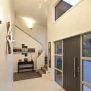 The spacious open plan living area flows seamlessly architecture, ceiling, daylighting, estate, floor, home, house, interior design, real estate, orange