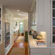 This kitchen blends with its surroundings through architectural bookcase, cabinetry, furniture, home, interior design, kitchen, living room, room, shelf, shelving, gray