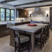 In this kitchen remodel by Doug Durbin, the cabinetry, countertop, cuisine classique, floor, flooring, hardwood, interior design, kitchen, laminate flooring, room, wood flooring, gray, black