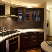 The graceful curves of this kitchen are picked cabinetry, countertop, flooring, interior design, kitchen, lighting, room, brown, black