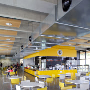 The clean-lined architecure of the facility is matched architecture, cafeteria, ceiling, interior design, yellow, gray