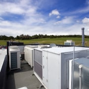 The clean-lined architecure of the facility is matched home, real estate, roof, sky, water, white, blue