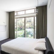 Sliding doors open to a Juliet balcony in architecture, bed frame, bedroom, ceiling, home, house, interior design, mattress, property, real estate, room, suite, window, window covering, window treatment, white