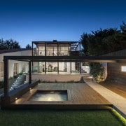 An exposed concrete pathway runs through the spotted architecture, backyard, cottage, daylighting, estate, facade, home, house, lighting, property, real estate, residential area, roof, siding, swimming pool, villa, window, black