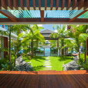 The view from this tropical home takes in arecales, backyard, condominium, courtyard, estate, home, house, interior design, leisure, mixed use, outdoor structure, palm tree, property, real estate, resort, roof, brown