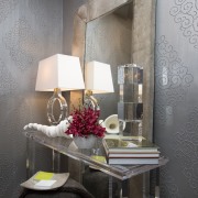 The clear acrylic table in this powder room chair, furniture, home, interior design, room, table, wall, gray, black