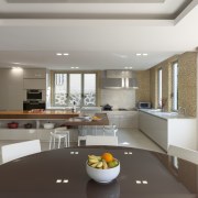 A large L-shaped island is the centrepiece of ceiling, countertop, interior design, kitchen, living room, real estate, gray