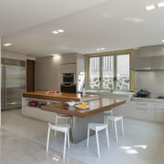 The kitchen in this home incorporates an L-shaped cabinetry, ceiling, countertop, floor, flooring, interior design, kitchen, real estate, room, gray