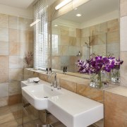 The bathroom in this home is lined with bathroom, floor, flooring, home, interior design, real estate, room, sink, tile, wall, gray, brown