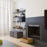 A blackboard fire surround downplays the presence of furniture, hearth, home appliance, interior design, living room, room, white, black