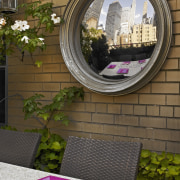 The Manhattan skyline is reflected in a convex arch, architecture, courtyard, flora, flower, grass, home, plant, purple, wall, window, brown