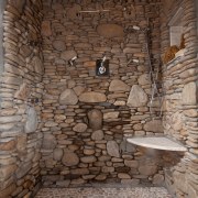 This grotto-style shower is lined with local Appalachian ancient history, stone wall, wall, brown, gray