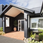 A soaring gabled canopy creates an inviting entry, facade, home, house, property, real estate, residential area, window, black, white