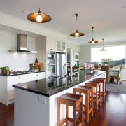 The island features a single slab of pure countertop, hardwood, home, interior design, kitchen, real estate, room, gray