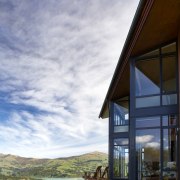 Sliding stacker doors open up the family room architecture, cloud, cottage, estate, facade, home, house, property, real estate, sky, sunlight, window, gray