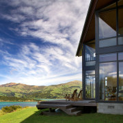 Sliding stacker doors open up the family room architecture, cloud, cottage, estate, home, house, property, real estate, reflection, sky, water, window, gray