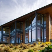 Designed by architect David Hill, this holiday house architecture, building, cottage, facade, home, house, real estate, sky, window, white, brown