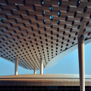 Looking much like a giant sculpture from both architecture, building, ceiling, daylighting, daytime, landmark, line, roof, sky, structure, symmetry, black