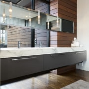 Objects and materials flow seamlessly from the outside cabinetry, countertop, floor, flooring, furniture, interior design, kitchen, sink, gray