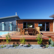 Sheltered deck at the rear of the house backyard, cottage, elevation, estate, facade, home, house, property, real estate, residential area, siding, villa, blue