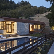 Raw materials are a feature of this rural architecture, cottage, estate, home, house, landscape, lighting, property, real estate, reflection, resort, villa, water, black