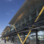 Railway stations, including New Lynn, have upgraded providing architecture, building, corporate headquarters, daytime, facade, fixed link, infrastructure, landmark, line, metropolis, metropolitan area, overpass, sky, skyway, structure, transport, urban area, black, blue