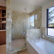 The shower is lined with onyx tiles. To architecture, bathroom, daylighting, estate, floor, flooring, home, interior design, real estate, room, tile, wall, window, gray