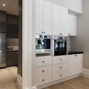 The L-shaped butlers pantry is contemporary, with modern cabinetry, countertop, floor, home appliance, interior design, kitchen, room, gray