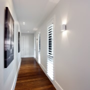 White walls in this circulation area provide a apartment, architecture, ceiling, daylighting, floor, flooring, hardwood, home, house, interior design, lighting, real estate, room, wood, wood flooring, gray