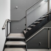 A perforated metal screen wraps right down one floor, handrail, product design, stairs, white, black, gray