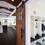 A mud room with a sliding barn door ceiling, floor, flooring, hardwood, home, house, interior design, real estate, room, wood flooring, white, gray