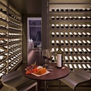 The climate-controlled wine cellar features custom, backlit wine interior design, wine cellar, winery, brown