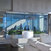 A large aquarium is a centerpiece in this architecture, condominium, daylighting, glass, home, house, interior design, lobby, real estate, gray