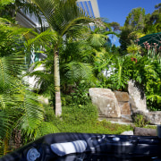 Bathers in the spa pool can be completely arecales, grass, landscape, landscaping, leaf, majorelle blue, outdoor structure, palm tree, plant, reflection, resort, sky, tree, tropics, vegetation, water, woody plant, green