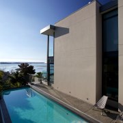 To conserve heat in the pool, an automatically apartment, architecture, building, condominium, daytime, estate, facade, home, house, property, real estate, sea, sky, swimming pool, vacation, villa, water, teal