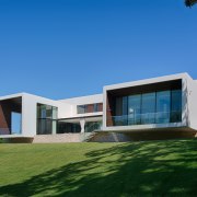 Cantilevered wings project out over the ridge on architecture, building, corporate headquarters, cottage, daytime, elevation, estate, facade, home, house, property, real estate, residential area, sky, villa, window, teal