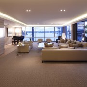 The formal living area includes a bar clad ceiling, floor, flooring, interior design, living room, penthouse apartment, real estate, window, brown