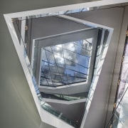 A huge cantilevered reflector frame on top of architecture, daylighting, glass, product design, structure, window, gray