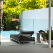 A glass pool fence in this garden ensures architecture, backyard, courtyard, flowerpot, furniture, glass, grass, home, house, interior design, outdoor furniture, plant, property, table, wall, gray, white