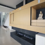 This basalt-clad wall provides structural support, acts as architecture, floor, flooring, furniture, house, interior design, lobby, product design, table, wall, wood, gray