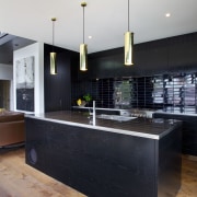 In this black kitchen there are three brass architecture, countertop, interior design, kitchen, black, white