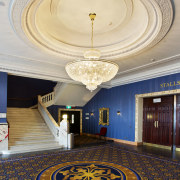 :Custom chandeliers at the Isaac Theatre Royal were architecture, ceiling, column, daylighting, estate, floor, flooring, interior design, lobby, structure, symmetry, wall, gray