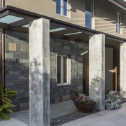 The main entrance to this renovated house is door, facade, home, house, porch, real estate, residential area, siding, window, black, gray