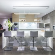 This contemporary kitchen in a renovated 1970s house ceiling, countertop, interior design, kitchen, real estate, table, gray, white